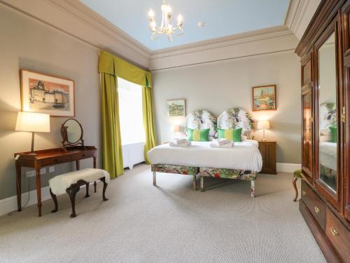 a bedroom with a bed and a desk and a window at Macdui - Mar Lodge Estate in Ballater