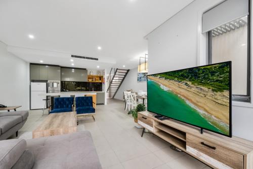 a living room with a large flat screen tv at Pullman Magenta Shores Resort in The Entrance