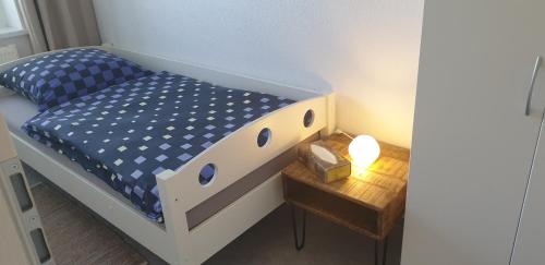 a small bed in a small room with a table at Möblierte Wohnung auf Zeit in Mühlhausen
