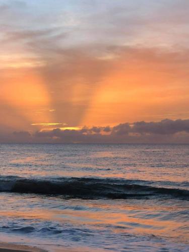 a sunset over the ocean with a beach at Atlantic Wave Villa in Aguada