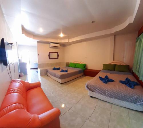 a living room with two beds and a couch at คิวทอง บังกะโล (Q-Thong bungalow) in Ko Larn
