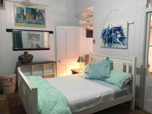 - une chambre avec un lit blanc et des oreillers bleus dans l'établissement Spacious Suite, à Townsville