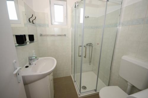 y baño con ducha, lavabo y aseo. en Kenderhordó Pihenőház, en Zánka
