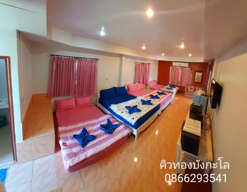 een woonkamer met 2 bedden en een televisie bij คิวทอง บังกะโล (Q-Thong bungalow) in Ko Larn