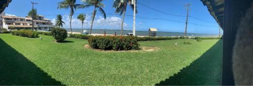 a lawn with birds on it next to a beach at Apart-Hotel Beira Mar em Mar Grande in Aratuba Beach