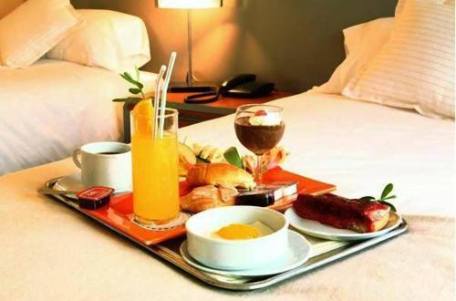 a tray with breakfast foods and drinks on a bed at Hotel Eurotel El Bosque in Santiago