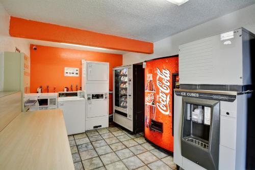 a kitchen with a coke machine and an orange wall at Motel 6-Southington, CT - Hartford in Southington