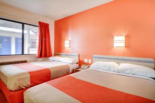 two beds in a room with orange walls at Motel 6-Southington, CT - Hartford in Southington