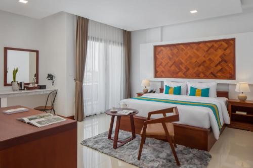a bedroom with a bed and a table and a chair at Homewood Hotel By Seuya Hotel in Siem Reap