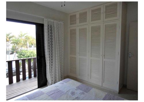 une chambre avec un lit et une fenêtre avec un balcon dans l'établissement Guarujá, apartamento a 100 metros da praia da enseada., à Guarujá