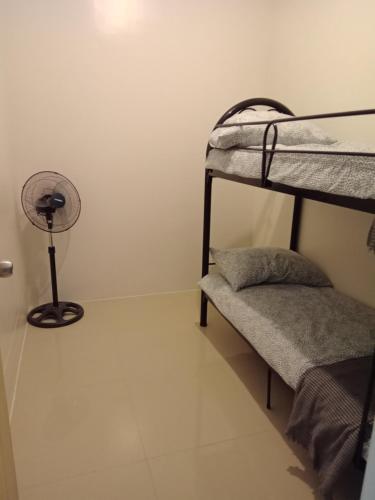 Zimmer mit 2 Etagenbetten und einem Ventilator in der Unterkunft Family freindly 2 bedroom condo at Vine Residences in Manila