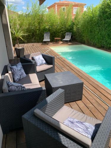 une terrasse avec des chaises et une piscine dans l'établissement Villa Cosy avec piscine, à Pierrelatte