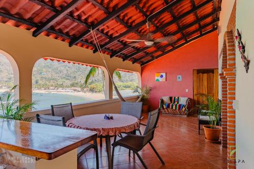 a dining room with a table and chairs and a view of the ocean at Casa Vista Magica in Yelapa