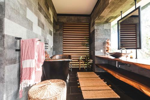 une salle de bain avec une grande baignoire et un lavabo dans l'établissement 3 Bedrooms Tropical Modernism Rice Field and Jungle, à Ubud