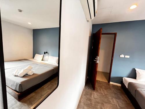 a bedroom with two beds and a mirror at WiRE BANGKOK PRAKHANONG in Amphoe Phra Khanong