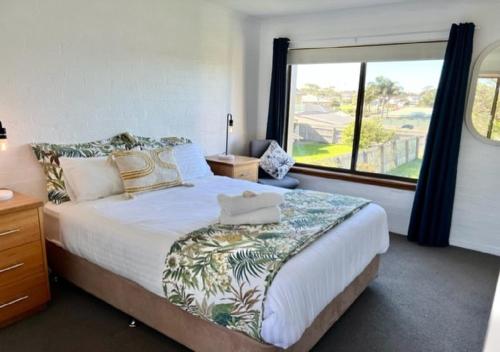 - une chambre avec un lit et une grande fenêtre dans l'établissement Vista Marina - 2 bedroom Apartment - Amazing views & location, à Bermagui
