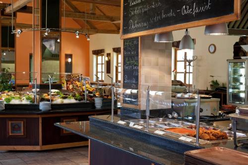 a restaurant with a buffet of food on a counter at Gastland M0 Hotel & Conference Center in Szigetszentmiklós