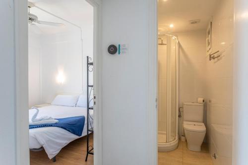 a bathroom with a bed and a shower and a toilet at Apartamentos Piza - Grupo Berna in Colònia de Sant Jordi