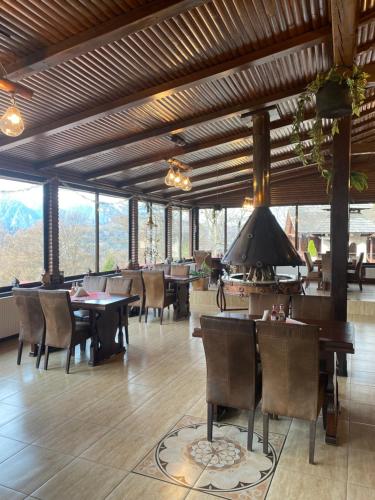 a dining room with tables and chairs and windows at Cabana Trei Brazi in Predeal
