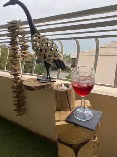 un oiseau assis sur un grand livre avec un verre de vin dans l'établissement Face mer cannes, à Cannes