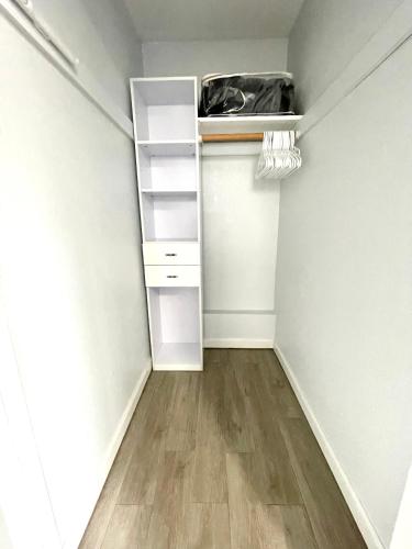 an empty closet with white shelves and a wooden floor at Golden Gate Park Suite in San Francisco