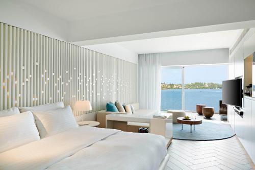 a bedroom with a bed and a living room at Nikki Beach Resort & Spa Porto Heli in Porto Heli