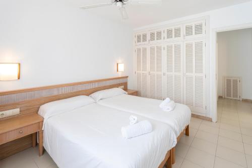 a bedroom with two white towels on a bed at Apartamentos Lemar in Colonia Sant Jordi