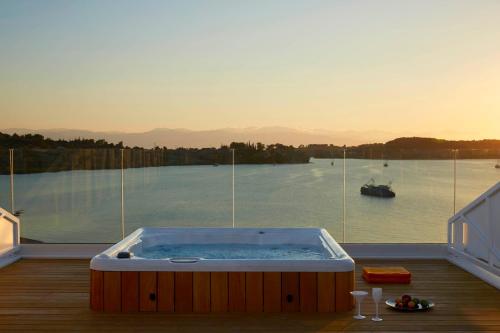 a hot tub on a deck with a view of the water at Nikki Beach Resort & Spa Porto Heli in Porto Heli
