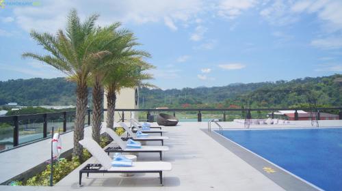 a row of lounge chairs next to a swimming pool at Le Charmé Suites - Subic in Olongapo