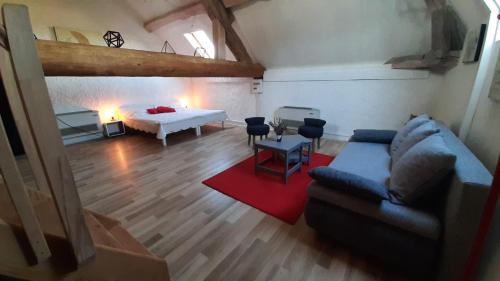 ein Wohnzimmer mit einem Sofa und einem Bett in der Unterkunft Gîte Chez Léo in Varennes-sur-le-Doubs