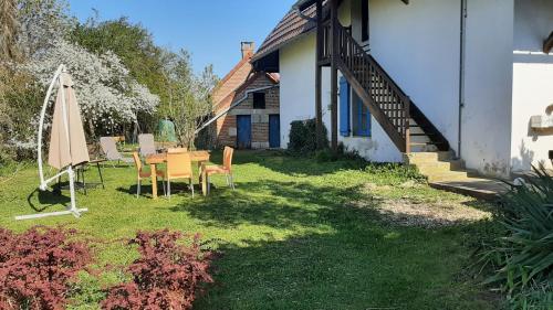 einen Tisch und Stühle im Hof eines Hauses in der Unterkunft Gîte Chez Léo in Varennes-sur-le-Doubs
