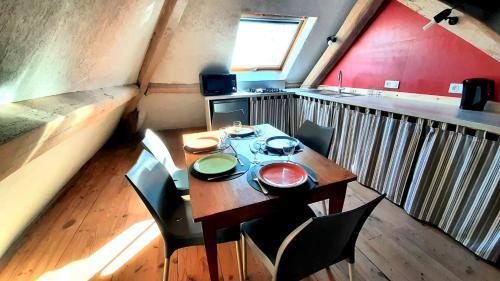 a table and chairs in a small room with a kitchen at Gîte Chez Léo in Varennes-sur-le-Doubs