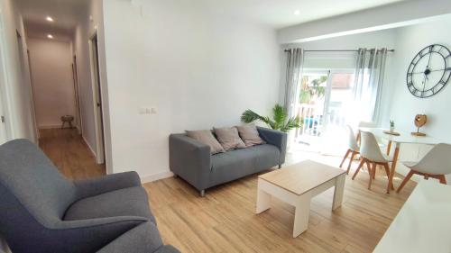 salon z kanapą i stołem w obiekcie EA! Las Arenas Family - Alojamientos La Torre w mieście Torre del Mar