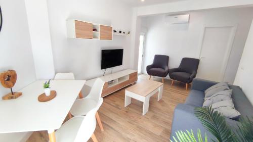 salon z kanapą i stołem w obiekcie EA! Las Arenas Family - Alojamientos La Torre w mieście Torre del Mar