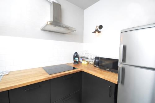 a kitchen with a refrigerator and a wooden counter top at Schindler’s Factory Zabłocie Deluxe Apartments WAWELOFTS in Kraków