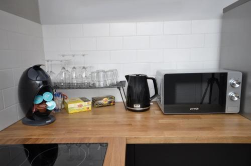 a kitchen counter with a microwave and a coffee maker at Schindler’s Factory Zabłocie Deluxe Apartments WAWELOFTS in Kraków