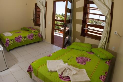 two twin beds in a room with a window at POUSADA MARINA PRAiA in Beberibe