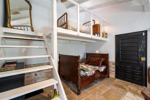 a bedroom with bunk beds and a bed and a ladder at Casa en olivera a 3 km de la costa in Perelló