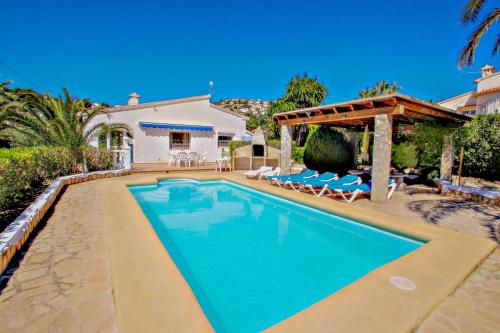 a swimming pool in front of a house with a gazebo at Kathrin - beautiful little house in pretty grounds with lovely views in Benissa in Benissa