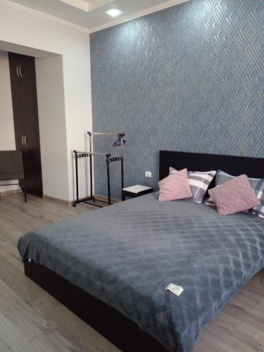 um quarto com uma cama grande e almofadas cor-de-rosa em Апартаменты в центре города em Chernivtsi