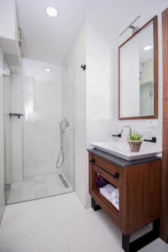 a bathroom with a sink and a shower with a mirror at Hotel Bograd - Apartments & Lounge Station in Struga