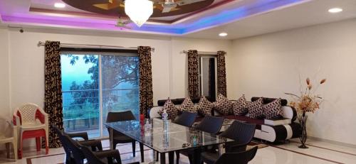 a dining room with a table and a couch at Shriyan Farmhouse Mahabaleshwar in Mahabaleshwar