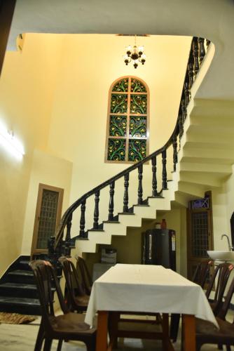 a staircase in a building with a table and chairs at jayaram Home in Chittoor