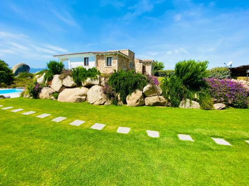 a house in the middle of a yard with rocks at Art Villa in San Teodoro
