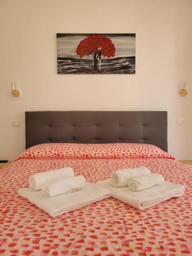 a bed with two white towels on top of it at Casa "Paolo e Francesca" Monolocali in Scilla