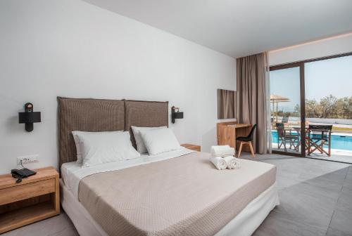 a bedroom with a bed and a view of a pool at Terra Pietra Luxury Villas & Suites in Lardos