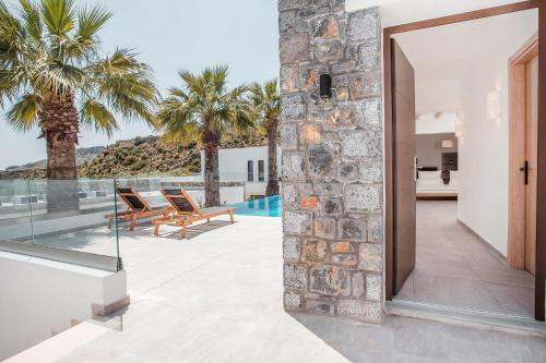 an open door to a patio with palm trees at Terra Pietra Luxury Villas & Suites in Lardos