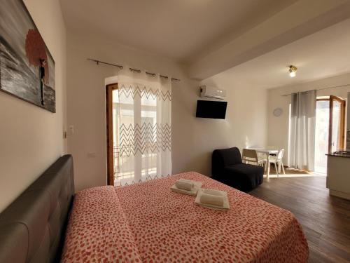 a bedroom with a bed and a living room at Casa "Paolo e Francesca" Monolocali in Scilla