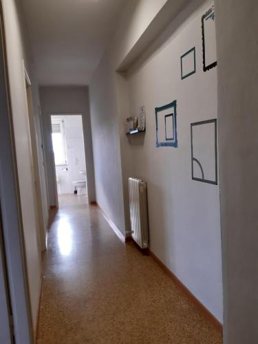 um corredor vazio com um radiador e imagens na parede em 6daNoi bis em Ivrea