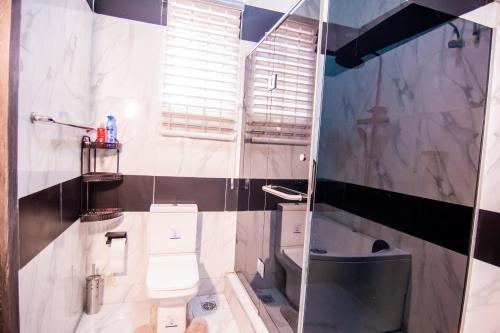 ein Badezimmer mit Toilette und Glasdusche in der Unterkunft Executive 4 bedroom house in Lagos